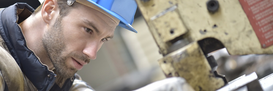 Industrial worker working on machine in factory 900x300.png